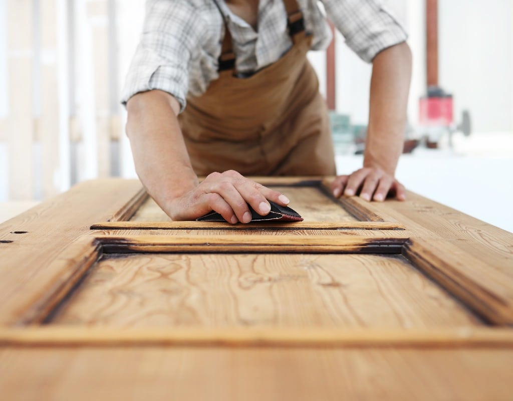 carpenter work the wood with the sandpaper